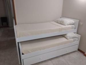 a white bunk bed with two mattresses on it at La Perla in Mar del Plata