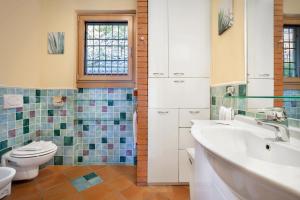 a bathroom with a sink toilet and a window at Villetta Blue Panorama With Jacuzzi in Torri del Benaco +18 photos