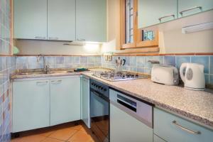 a kitchen with white cabinets and a counter top at Villetta Blue Panorama With Jacuzzi in Torri del Benaco