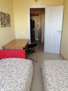 Habitación con cama, escritorio y mesa. en "La casa di Mariagrazia" rooms con cucina condivisa e terrazza en Sammichele di Bari