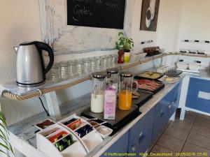 a kitchen counter with two bottles of juice and glasses at Hostel Hof Kranichstein in Kluis +3 photos
