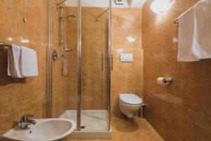 a bathroom with a shower and a toilet and a sink at B&B Garni Villa Campitello in Campitello di Fassa