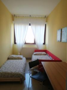 um quarto com duas camas e uma janela em "La casa di Mariagrazia" Appartamento 4 locali em Sammichele di Bari