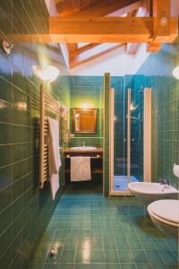 a green bathroom with a sink and a tub at B&B Garni Villa Campitello in Campitello di Fassa
