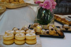 una mesa con un montón de donuts y otros pasteles en Life Hotels Kalaonda Resort, en Siracusa