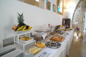 ein Buffet mit Obst und anderen Speisen auf dem Tisch in der Unterkunft Life Hotels Kalaonda Resort in Syrakus