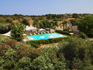 - une vue sur la piscine bordée de parasols dans l'établissement Life Hotels Kalaonda Resort, à Syracuse