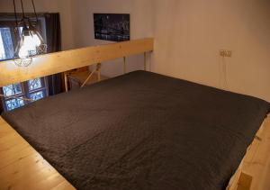 - une chambre avec un lit et une couette noire dans l'établissement Oktogon apartman, à Budapest
