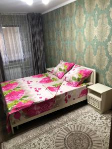 1 dormitorio con cama con sábanas rosas y almohadas rosas en квартира с красивым видом на море, en Aktau