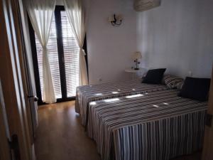 1 Schlafzimmer mit 2 Betten und einem großen Fenster in der Unterkunft Ferienhaus Casa Ela Pedro - Hinojos 4 Zi - 8 Betten, Kinder Willkommen in Hinojos
