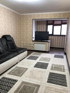 - un salon avec un lit et une télévision à écran plat dans l'établissement квартира с красивым видом на море, à Aktau