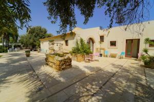 a house with a patio and a building at Life Hotels Kalaonda Resort in Siracusa