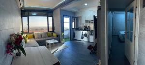 ein Wohnzimmer und eine Küche mit einem Sofa und einem Tisch in der Unterkunft Scenic Family Apt overlooking Agadir in Agadir