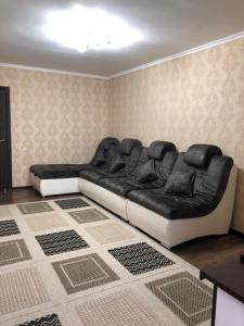 un sofá blanco y negro en una habitación en квартира с красивым видом на море, en Aktau