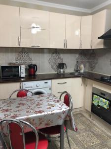 a kitchen with a table and chairs and a microwave at квартира с красивым видом на море in Aktau