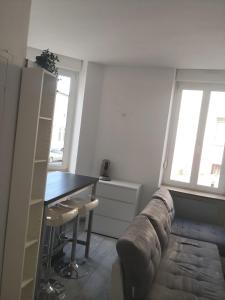 een woonkamer met een bank en een tafel bij Le Cosy Studio Logement entier [Parking Gratuit] in Algrange