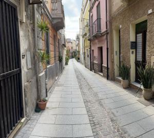 un callejón vacío con macetas y edificios en Casa Victoria IUN Q5032, en Cagliari