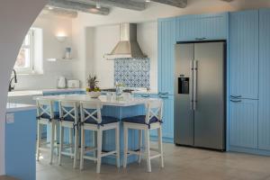 a kitchen with blue cabinets and a blue island with stools at Villa Everlong in Vamos