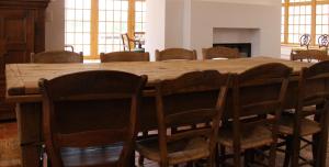 a dining room with a wooden table and chairs at Hoeve Luitenant Halleux in Linter