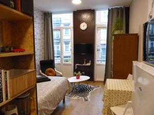 Cette petite chambre comprend un lit et une table. dans l'établissement Superbe Studio au 1er étage, proche de la gare du Midi, à Bruxelles