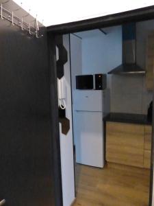 La cuisine est équipée d'un réfrigérateur blanc et d'un four micro-ondes. dans l'établissement Superbe Studio au 1er étage, proche de la gare du Midi, à Bruxelles