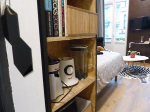 a book shelf with a blender in a room at Superbe Studio au 1er étage, proche de la gare du Midi in Brussels