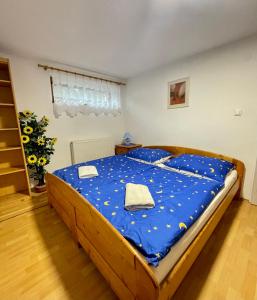 a bedroom with a large wooden bed with blue sheets at Apartmán Klaudia in Ružomberok