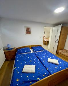 a bedroom with a large bed with blue sheets at Apartmán Klaudia in Ružomberok