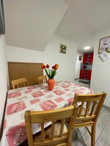 a dining room table with a vase of flowers on it at Apartmán Klaudia in Ružomberok