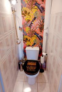 een badkamer met een toilet en een zwarte toiletbril bij Appart A l'abordage Sète, Gare, parking in Sète +7 foto's