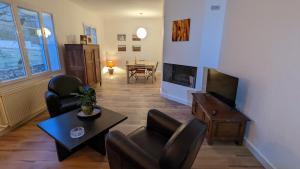 - un salon avec des chaises, une télévision et une table dans l'établissement Mas de vigneron, en Drôme provencale, à Rousset-les-Vignes