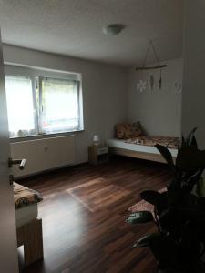a living room with a bed and a wooden floor at Ferienwohnung Im Drosselnest in Hechingen