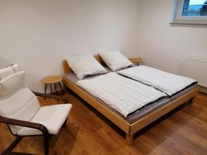 ein Bett und ein Stuhl in einem Zimmer in der Unterkunft Filder-Apartment in Filderstadt