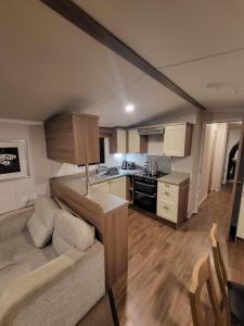 a kitchen with a couch and a table in a room at Caravan 66 Kensington at Marton Mere Holiday Park Blackpool in Blackpool