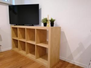 a tv stand with a television on top at Filder-Apartment in Filderstadt