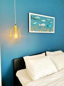 a blue wall with a picture above a bed at Room in Vung Tau- Blue Fish Deluxe Room- Phòng Bãi Sau Vũng Tàu in Vung Tau +10 photos