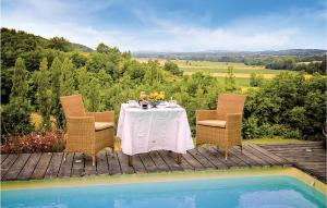 a table and chairs on a deck next to a pool at Awesome Home In Masseube With Sauna in Panassac