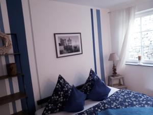 ein Schlafzimmer mit einem Bett mit blauen Kissen und einem Fenster in der Unterkunft Ferienwohnung am Spreeradweg in Bautzen in Bautzen