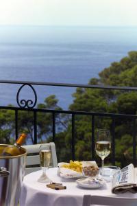 a table with a plate of food and two glasses of wine at Hotel La Floridiana in Capri