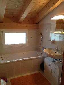 a bathroom with a tub and a sink at Casa Aurora in Sedrun