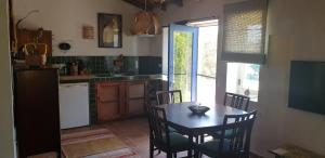 a kitchen with a table and chairs and a window at Montes de Baixo in Odeceixe +39 photos