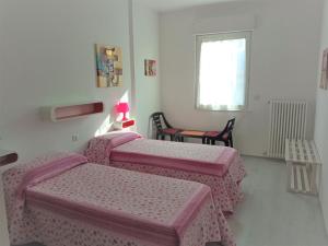 a room with three beds and a table and a window at Garden Belvedere B&B in Nago-Torbole
