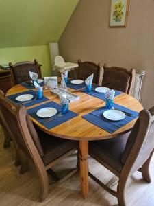a wooden table with blue napkins and plates on it at Amselpark in Barkelsby