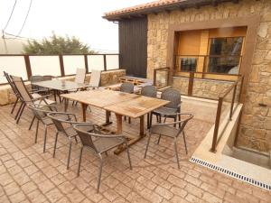 un patio con mesa de madera y sillas en Casa Rural A Ritmo De Burro, en Robledondo