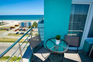 una mesa de cristal y sillas en un balcón con vistas a la playa en Apartament Crazy Summerland, en Mamaia