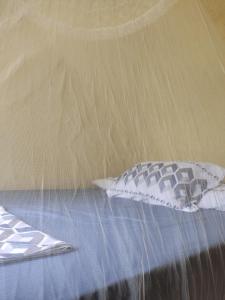 uma cama com duas almofadas em cima em Toca dos Prazeres Estalagem Bistrot em Igatu