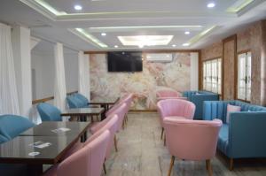 ein Restaurant mit Tischen und Stühlen und einem Flachbildfernseher in der Unterkunft Hotel al rayan in Tataouine