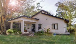 纳库鲁The Cabin的一座带草地庭院的白色小房子