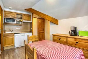 une cuisine avec une table et un chiffon de table rouge et blanc dans l'établissement Bel appartement au pied des pistes, à Valmeinier