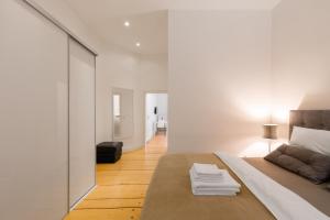Schlafzimmer mit einem Bett mit weißen Wänden und einem Spiegel in der Unterkunft Appartements an der Therme in Bad Ems